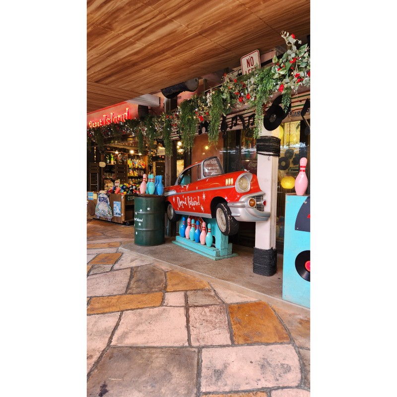 Red vintage car installation with bowling pins at Depot Island in American Village, Chatan, Okinawa