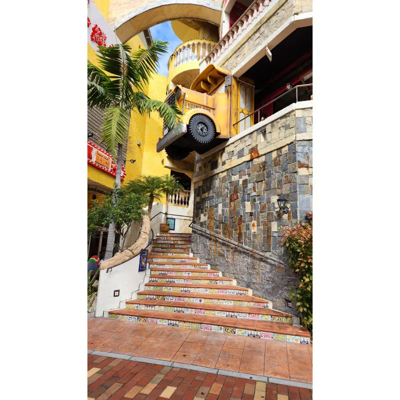 Yellow bus installation above tiled stairs at American Village in Chatan, Okinawa