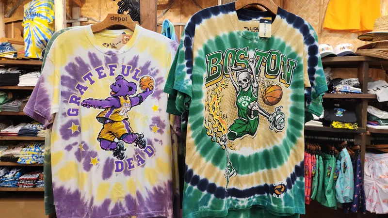 Tie-dye shirts with basketball and music designs at a shop in American Village, Chatan, Okinawa