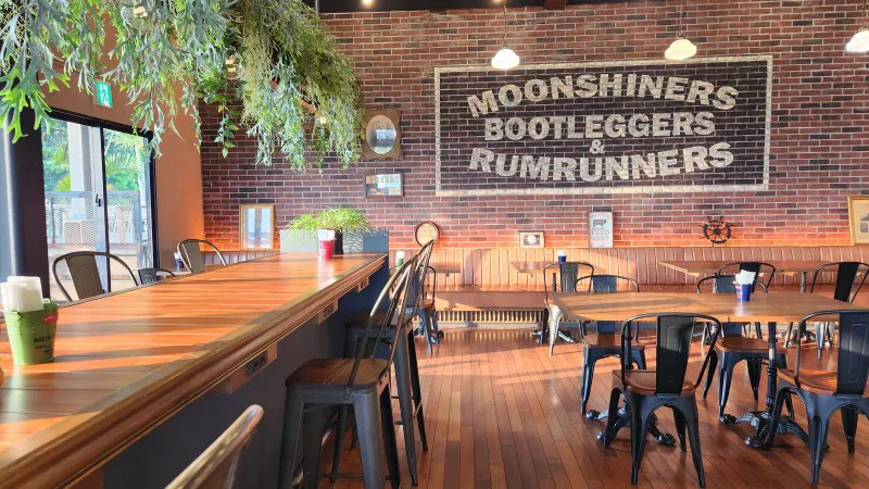 Interior of Caprice pub with wooden bar and brick wall design