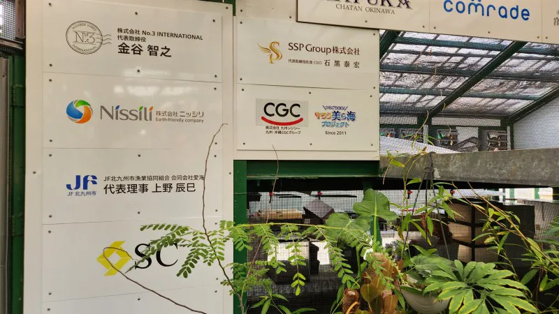 Sponsorship boards with company logos at Yomitan Coral Farm