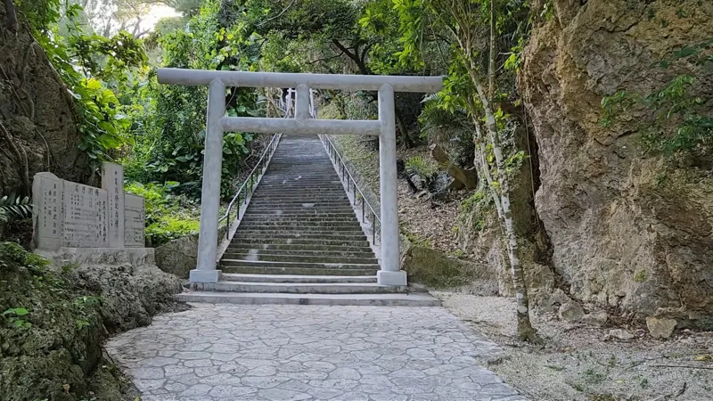 Torii et long escalier en pierre entourés de verdure à Hamahigajima