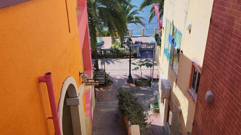 Alleyway with palm trees leading to the ocean at American Village in Chatan, Okinawa