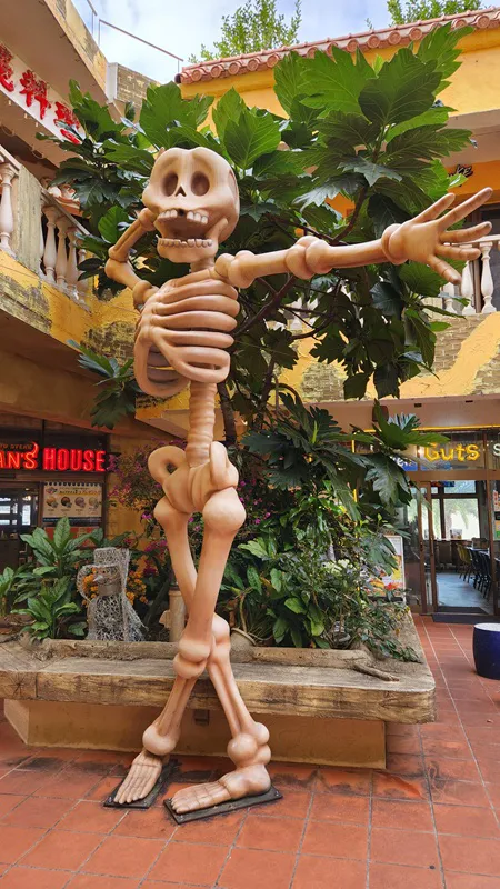 Large skeleton statue standing in a courtyard at American Village Okinawa