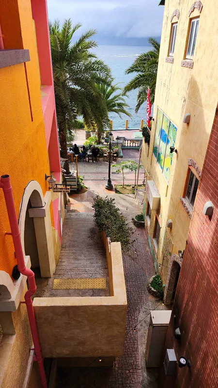 Colorful stairway between buildings leading toward the sea at American Village Okinawa