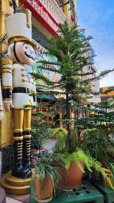 Large nutcracker statue surrounded by plants at Christmas Land Okinawa