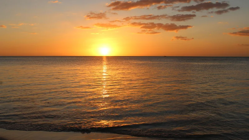 Sunset over the ocean at Yomitan Coral Farm beach