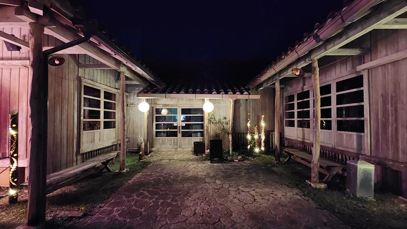 Illuminated wooden courtyard at night in Murasaki Mura Okinawa