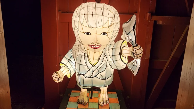 Lantern figure of a smiling woman Hikkake Yurei yokai holding a paper map at the Ryukyu Yokai Festival