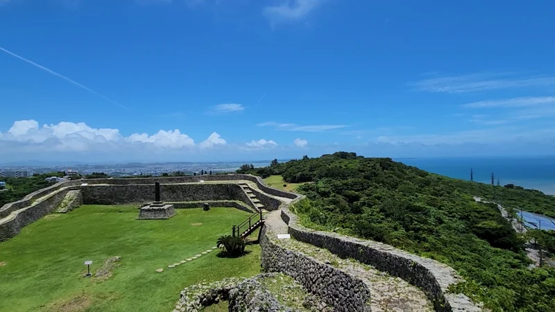 Panoramic view of Nakagusuku Castle inner enclosure with stone walls and ocean in the distance