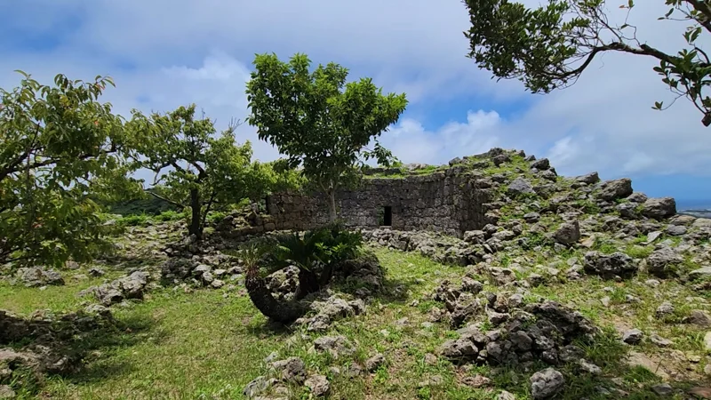 Ruins of a stone structure surrounded by trees at Nakagusuku Castle in Okinawa