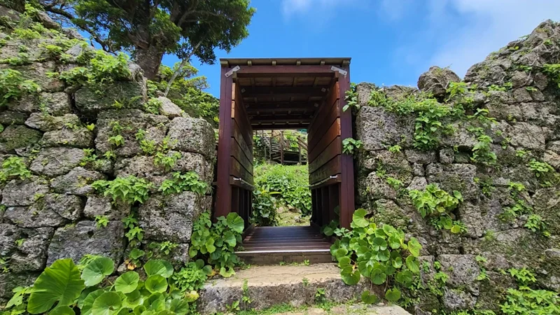Restored wooden gate on Nozura-zumi stone wall at Nakagusuku Castle ruins