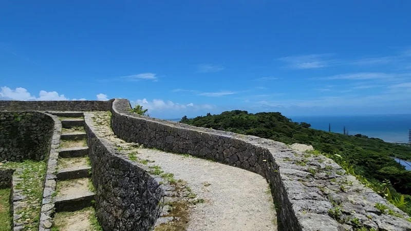 Curved Nozura-zumi stone walls of Nakagusuku Castle overlooking the ocean