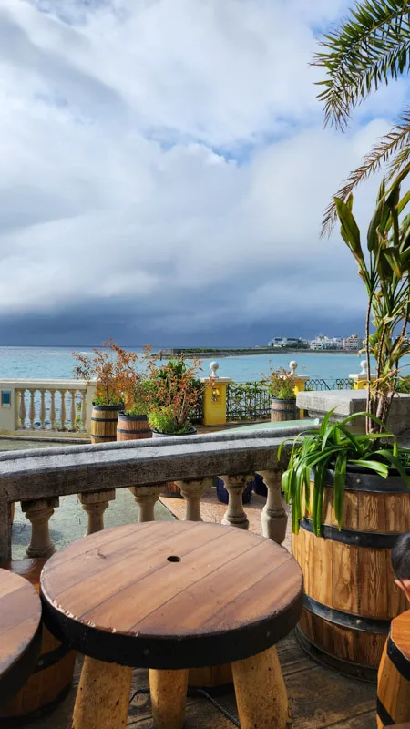Outdoor terrace with wooden tables overlooking the ocean in Okinawa