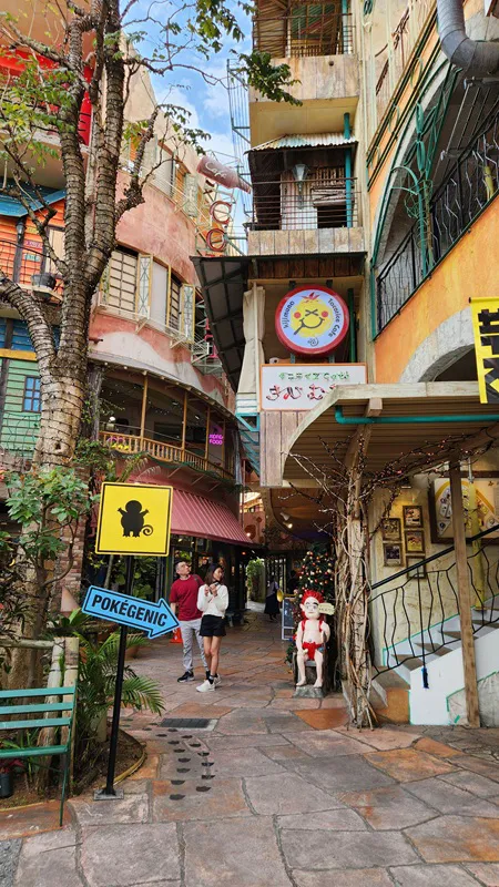 Narrow pedestrian alley with signs and decorations at American Village Okinawa