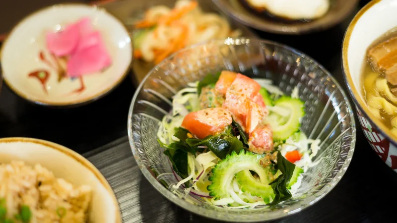 Assortment of traditional Okinawan dishes with goya and vegetables