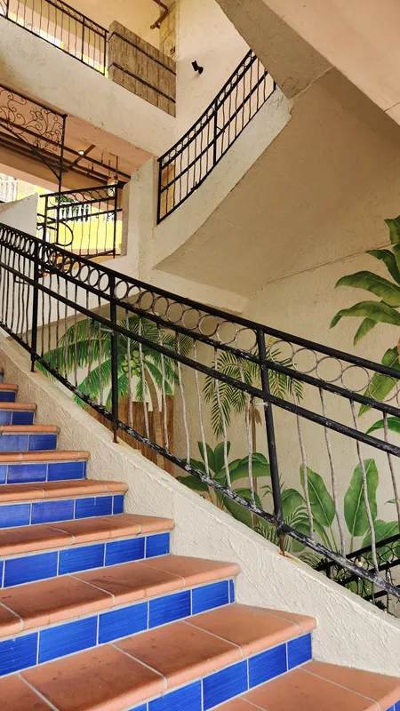 Indoor staircase with tropical leaf mural in Okinawa