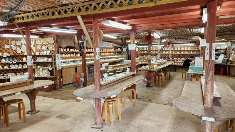 Craft workshop at Murasaki Mura with wooden tables and handmade souvenirs on display