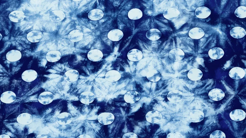 Indigo dyed fabric with circular dot pattern.