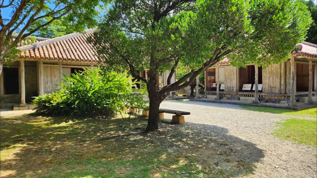 Courtyard of the Jitūdē’s traditional Okinawan house surrounded by trees and plants.