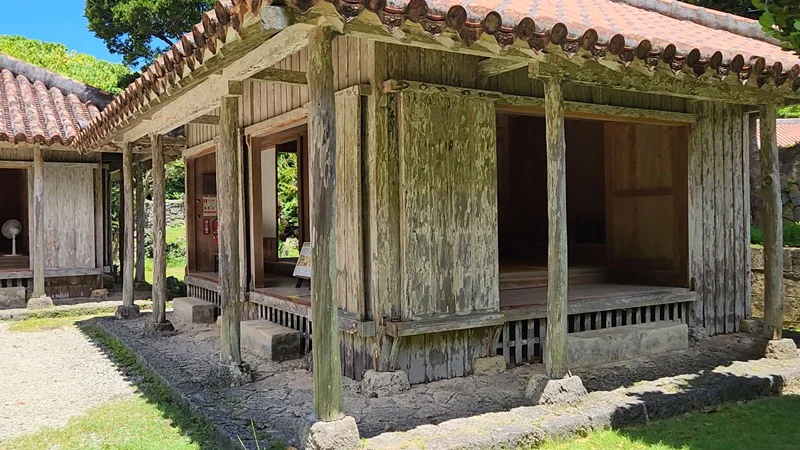 Close-up of an old wooden Okinawan house showing weathered wood and tiled roof at Jitūdē’s residence.