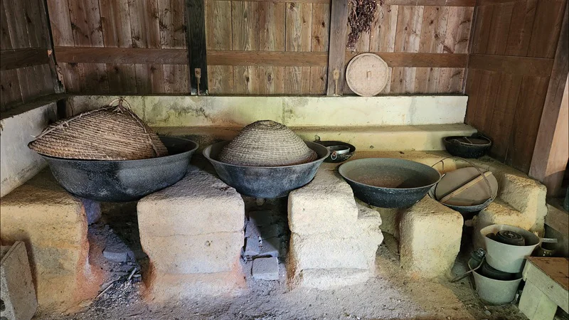 Traditional Okinawan kitchen with clay stoves and woven baskets inside Jitūdē’s house.
