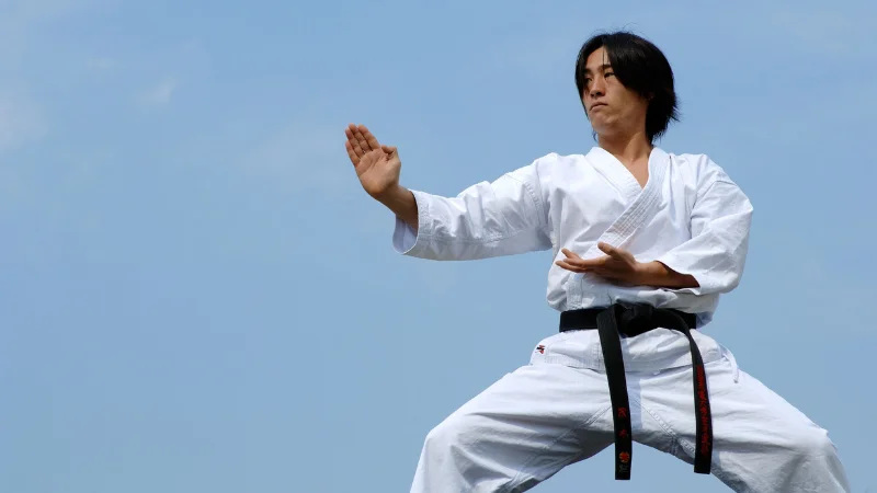 Karate master practicing kata outdoors in Okinawa.