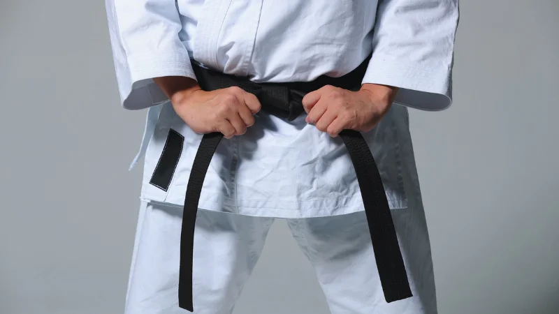 Close-up of karate black belt tied around gi.