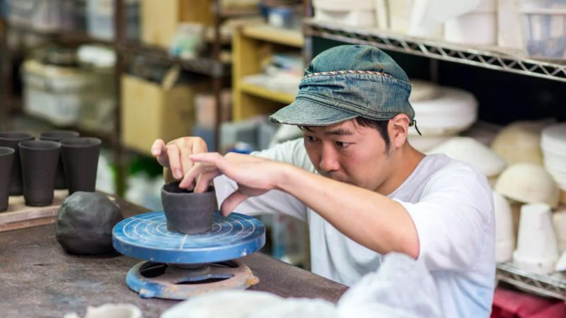 Artisan crafting a small clay vase