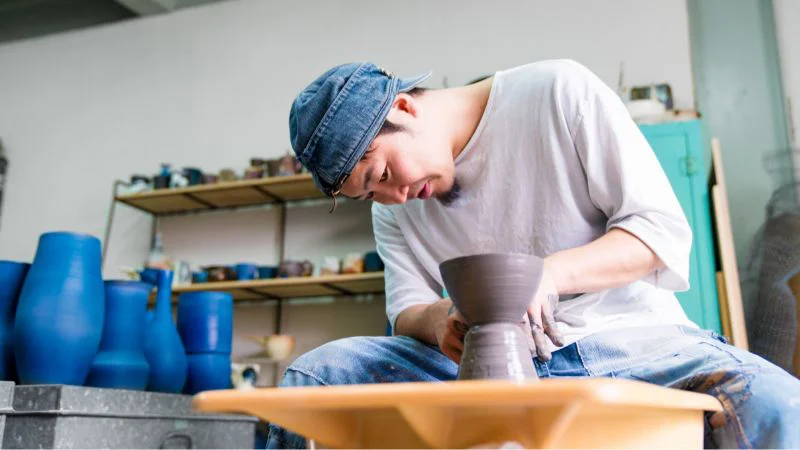 Artisan creating a clay vase on the wheel