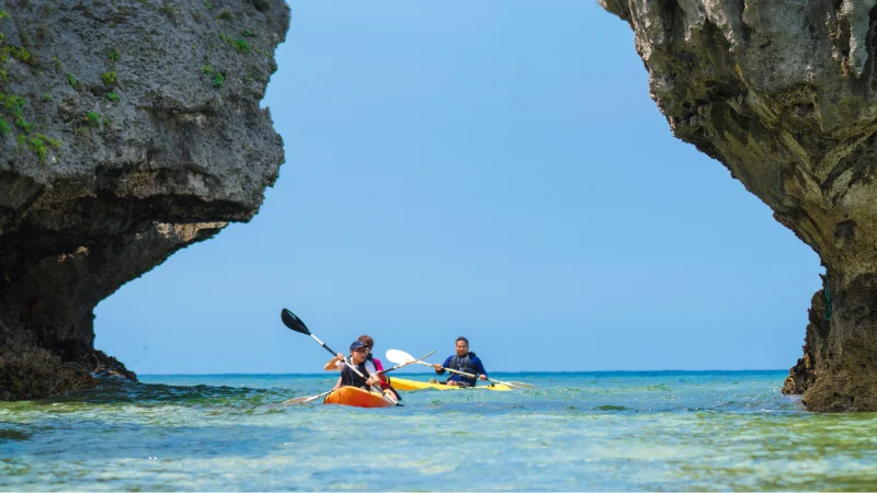 Kayakers paddling between the rocks at Cape Zanpa