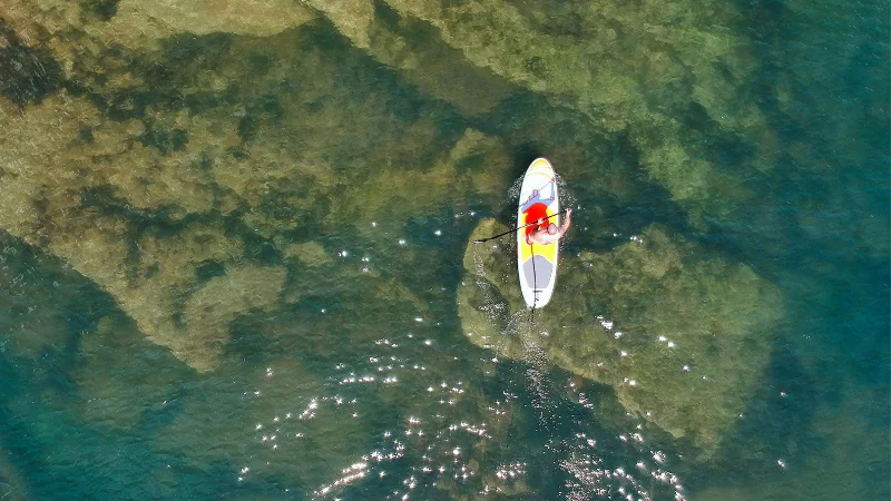 Person on a paddleboard on the clear water in Okinawa