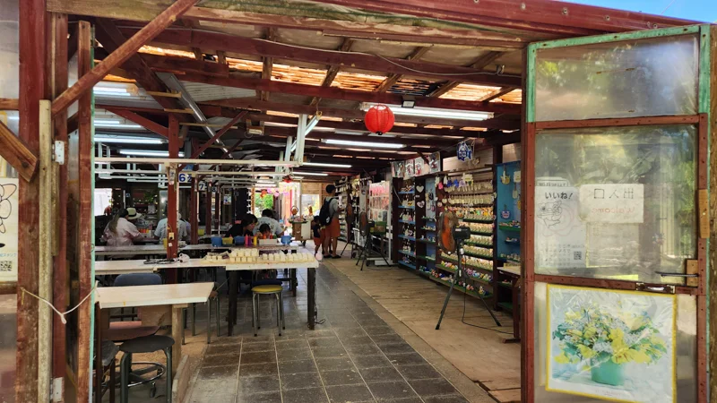 Craft area with tables and shelves of souvenirs at Murasaki Mura