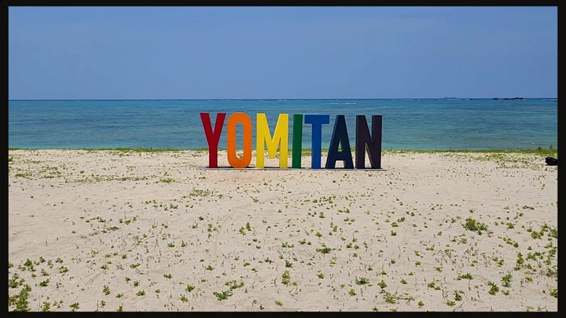 Colorful Yomitan sign on the sandy beach
