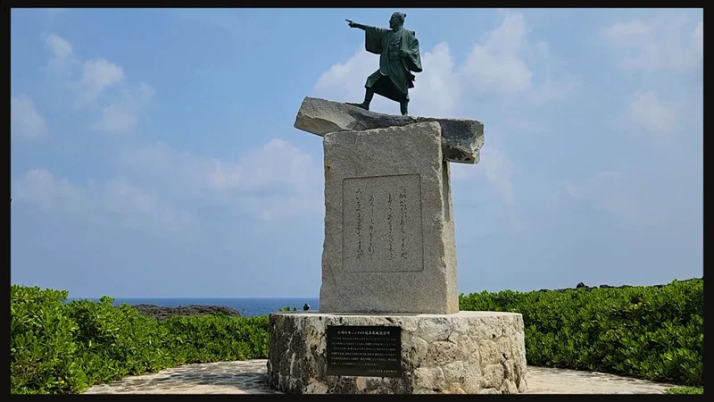 Bronze statue of Taiki on a stone pedestal at Cape Zanpa