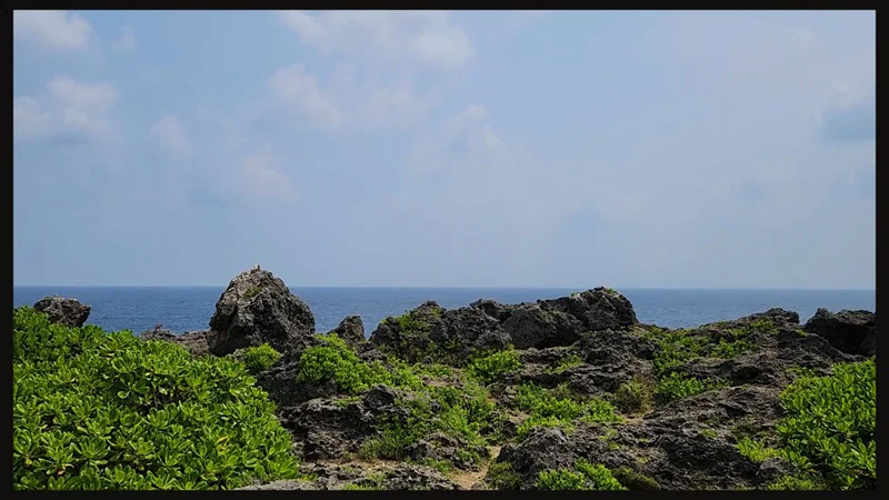 Dark rocks and blue sea at Cape Zanpa
