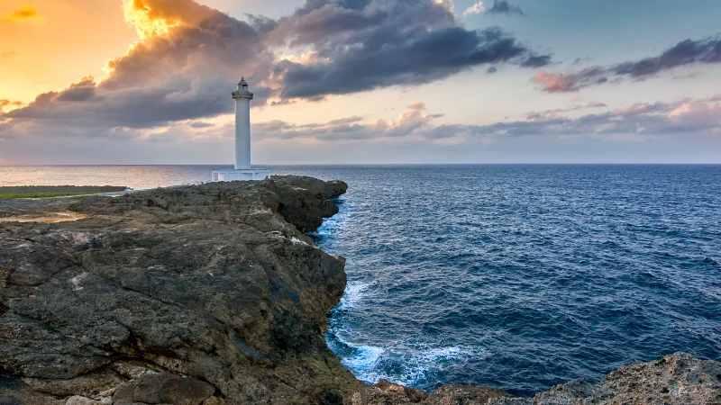 Zanpa lighthouse in silhouette against a colorful sky