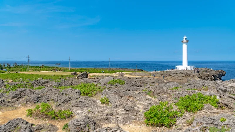 White Zanpa lighthouse on rocky Okinawan coast overlooking the blue sea