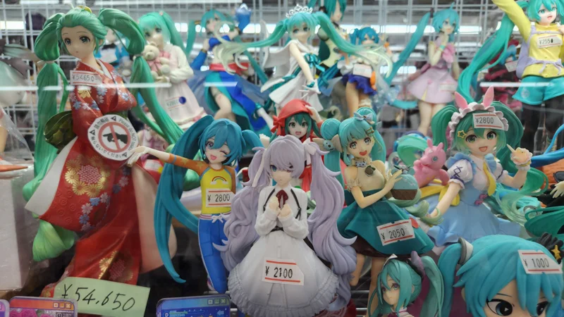 Colorful anime figures displayed in a shop, including various characters in different outfits and poses.