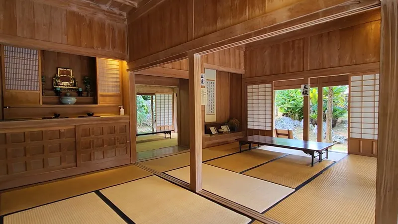 Tatami room with family altar and low table inside Jitūdē’s traditional Okinawan house.