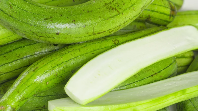Sliced and whole green luffa squash