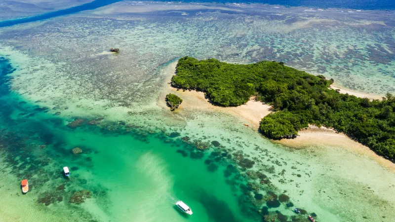 Aerial view of a small islet surrounded by a turquoise lagoon in Ishigaki