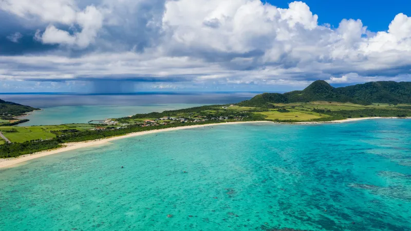White sand beach and turquoise sea in Ishigaki under a cloudy sky
