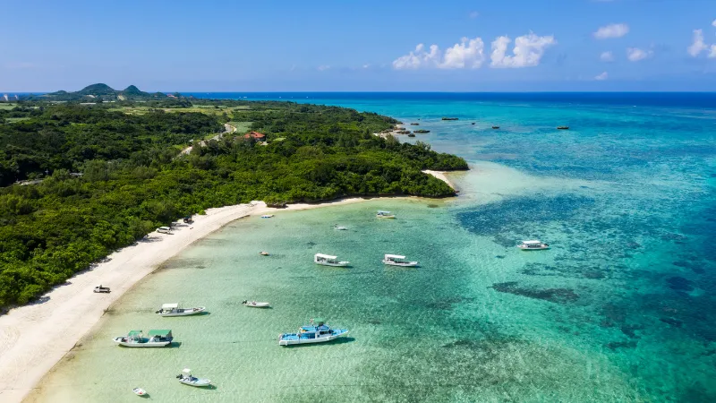 Small boats anchored in a clear shallow bay in Ishigaki