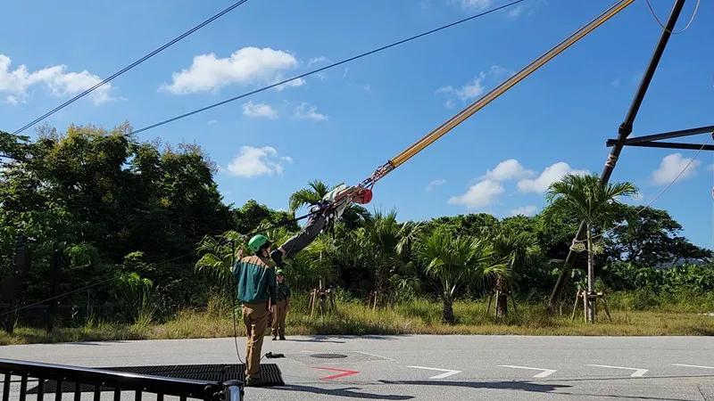 Staff assisting riders at the Human Arrow attraction in Junglia Okinawa