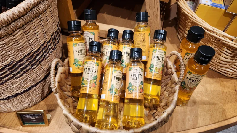 Bottles of Junglia Okinawa fruit sauce arranged in a woven basket
