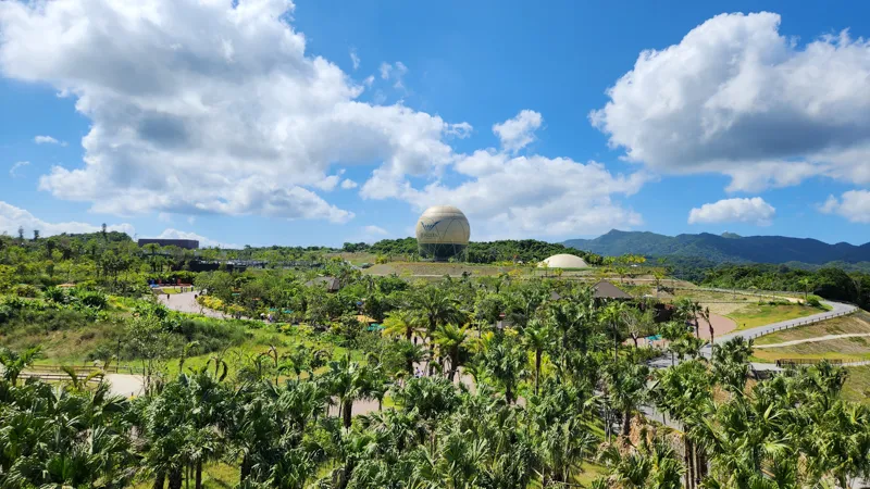 Panoramic view of Junglia Okinawa with tropical forest and large dome structure