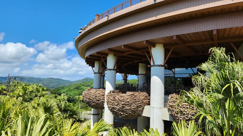 Nest style terraces on a wooden building surrounded by tropical plants at Junglia Okinawa