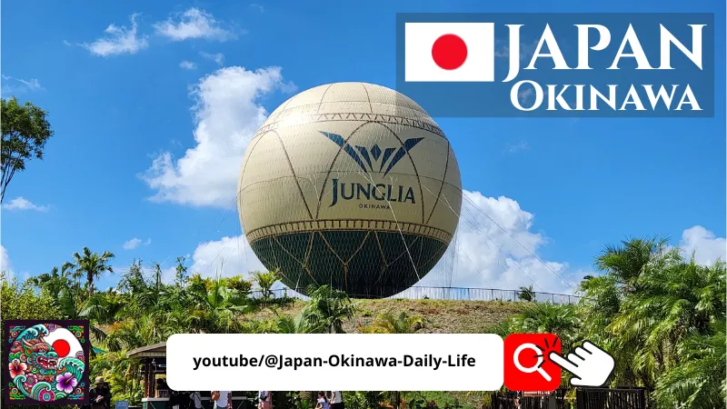 Large Junglia Okinawa hot air balloon rising above tropical plants under a bright blue sky for youtube video