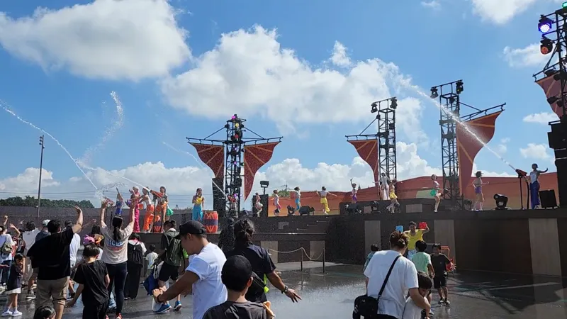 Water splash performance with dancers spraying water over the crowd at Junglia Okinawa